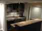 Wide view of basement bar with sink and wine rack