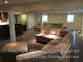 Wide view of finished basement with built-in bar